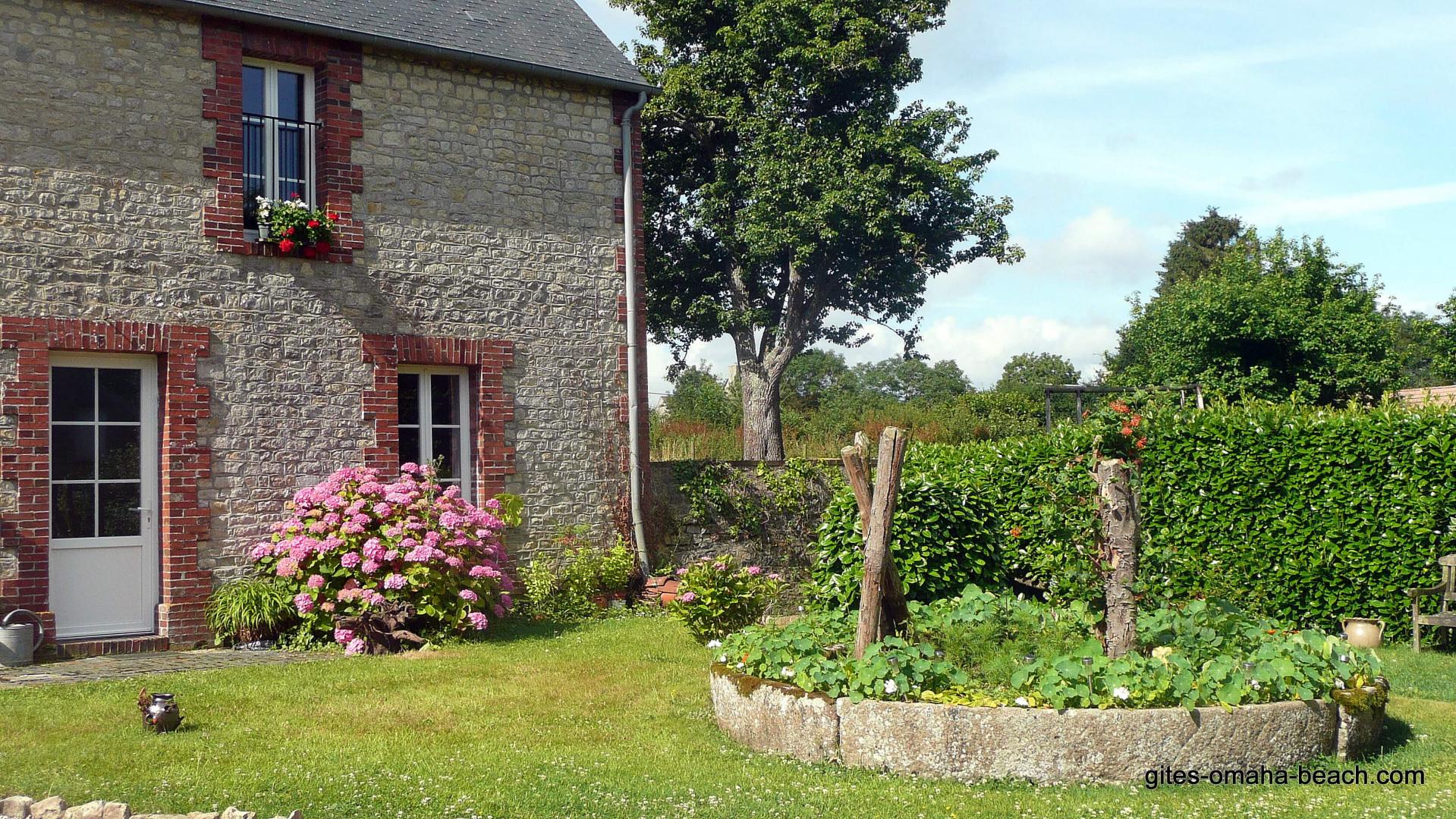 La façade du gîte, dans la cour principale, devant le pressoir